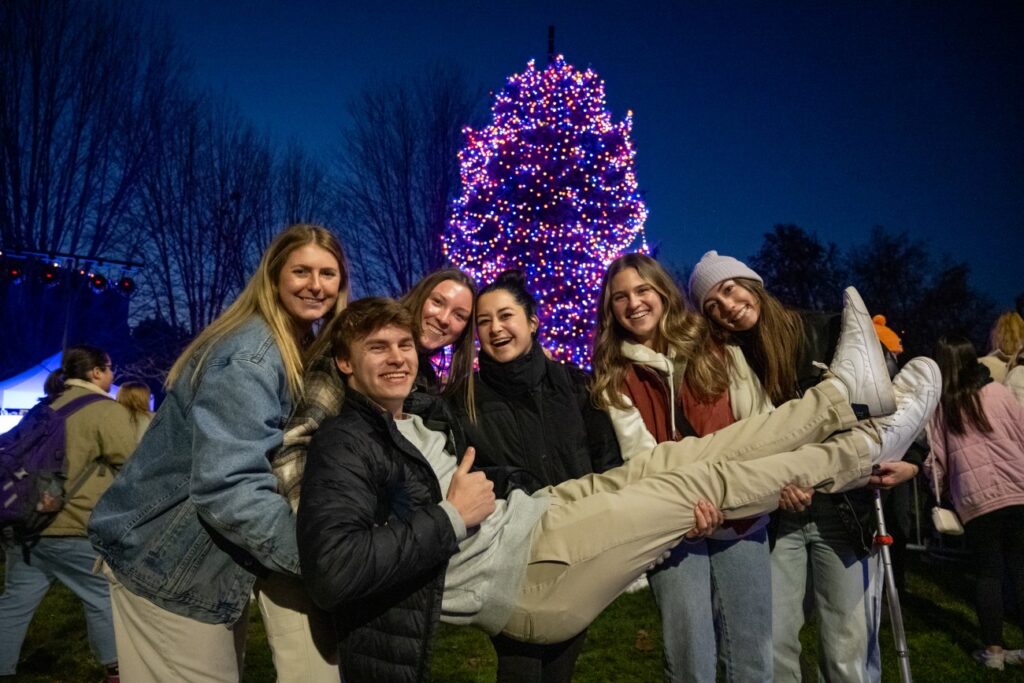 Group of students posing together at tree lighting event.