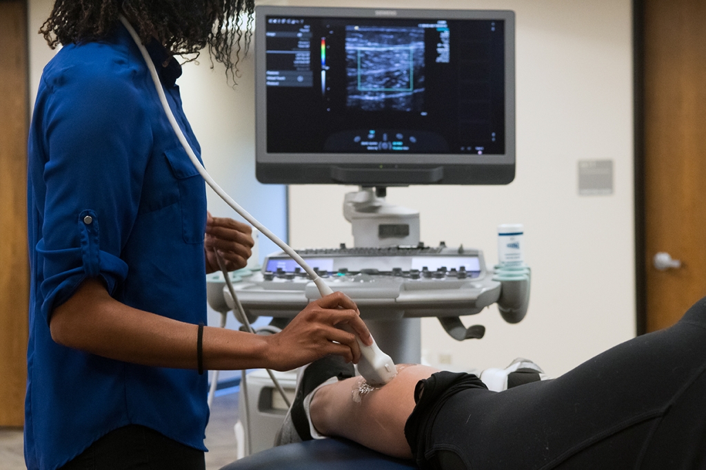 MAT student performing an ultrasound on a patients leg