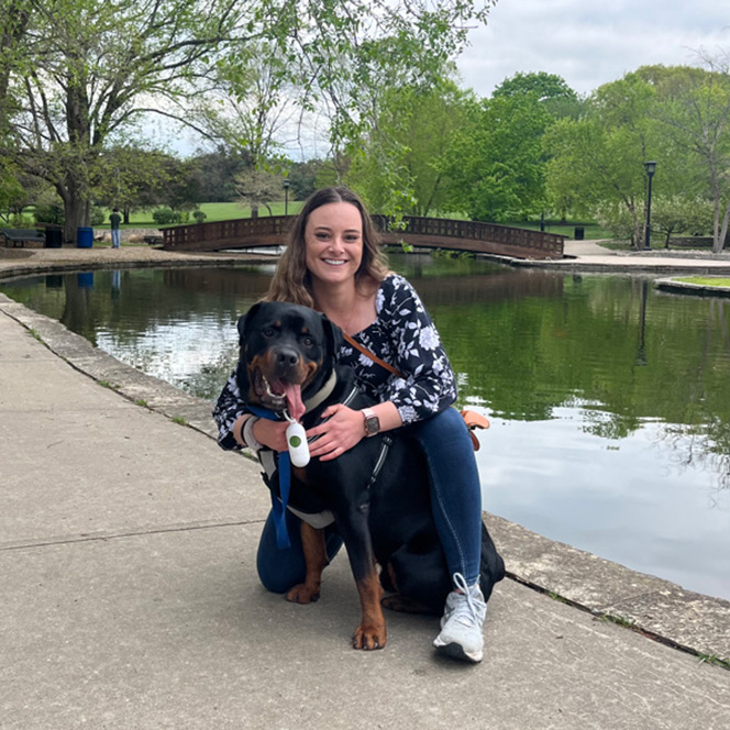 Alumni Erica Korbel at a park with her dog