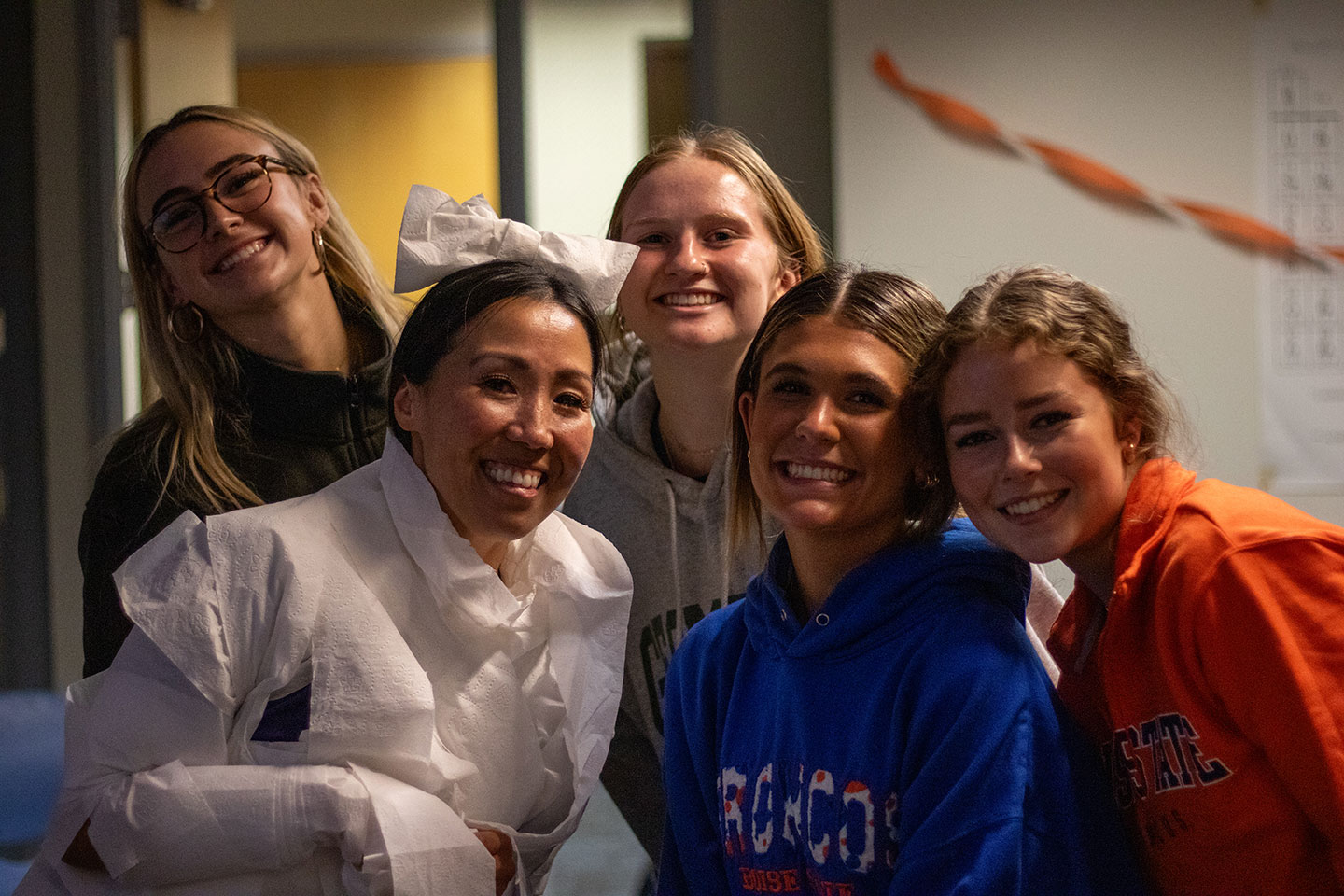 Mary Crowell, faculty in residence for the Health Professions Living Learning Community, poses as a mummy wrapped in toilet paper with four female students for Fright Night