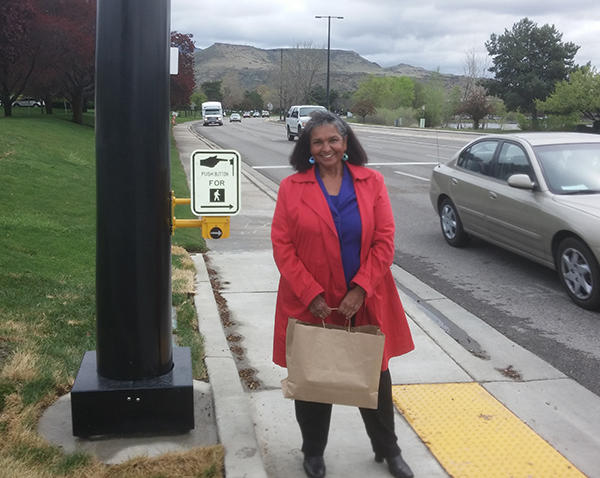 Olgie Castillo stands by the crosswalk light that she advocated for