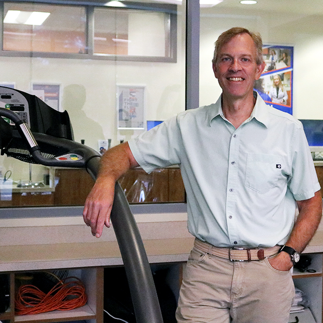 Tim Kempf stands next a treadmill in the Human Performance Laboratory