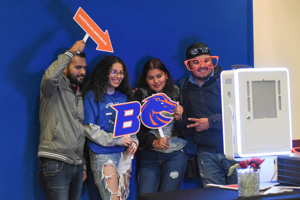 Visitors have fun with props in a Bronco Day photobooth