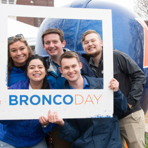 Students post with a Bronco Day polaroid prop