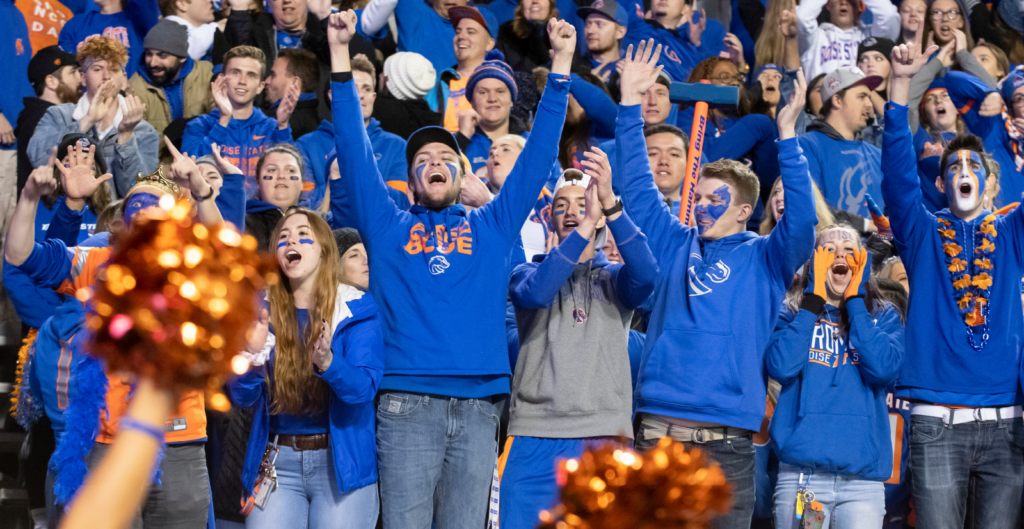 Student cheer on Broncos from the stands of the stadium.