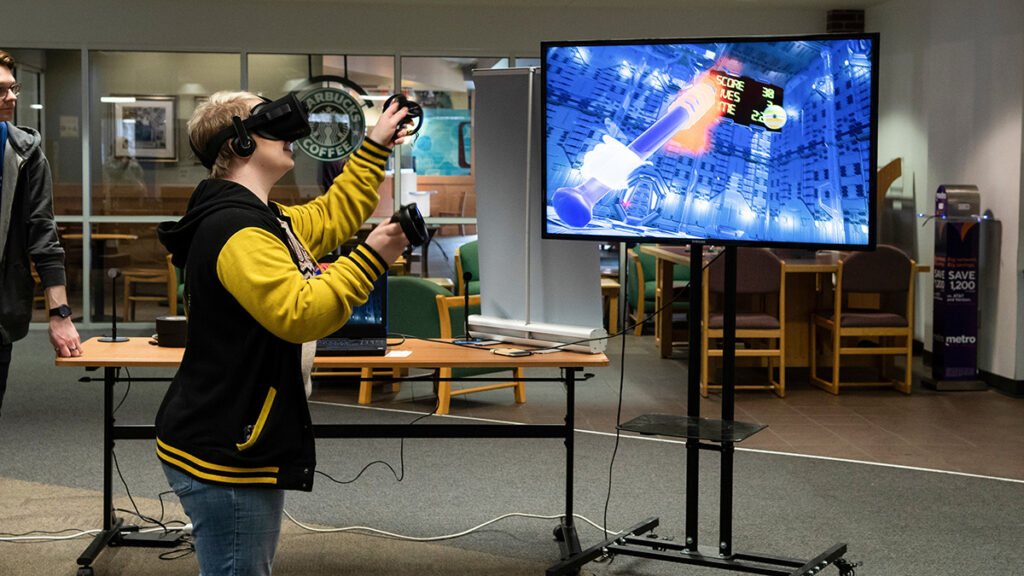 Student in the library demonstrating a virtual reality experience.