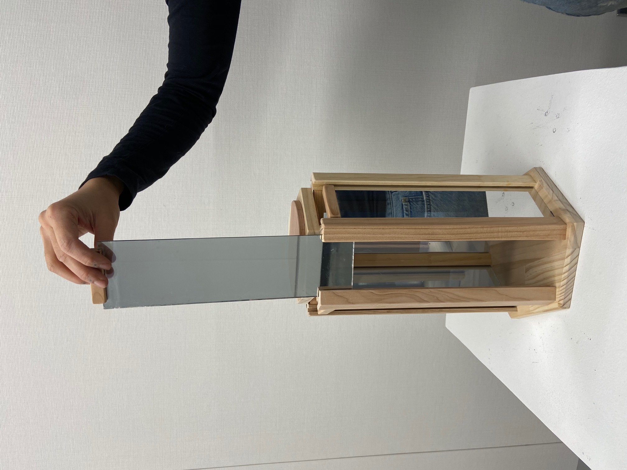 Photo of art work Box of Lies shows a wooden box with a mirror panel being raised.