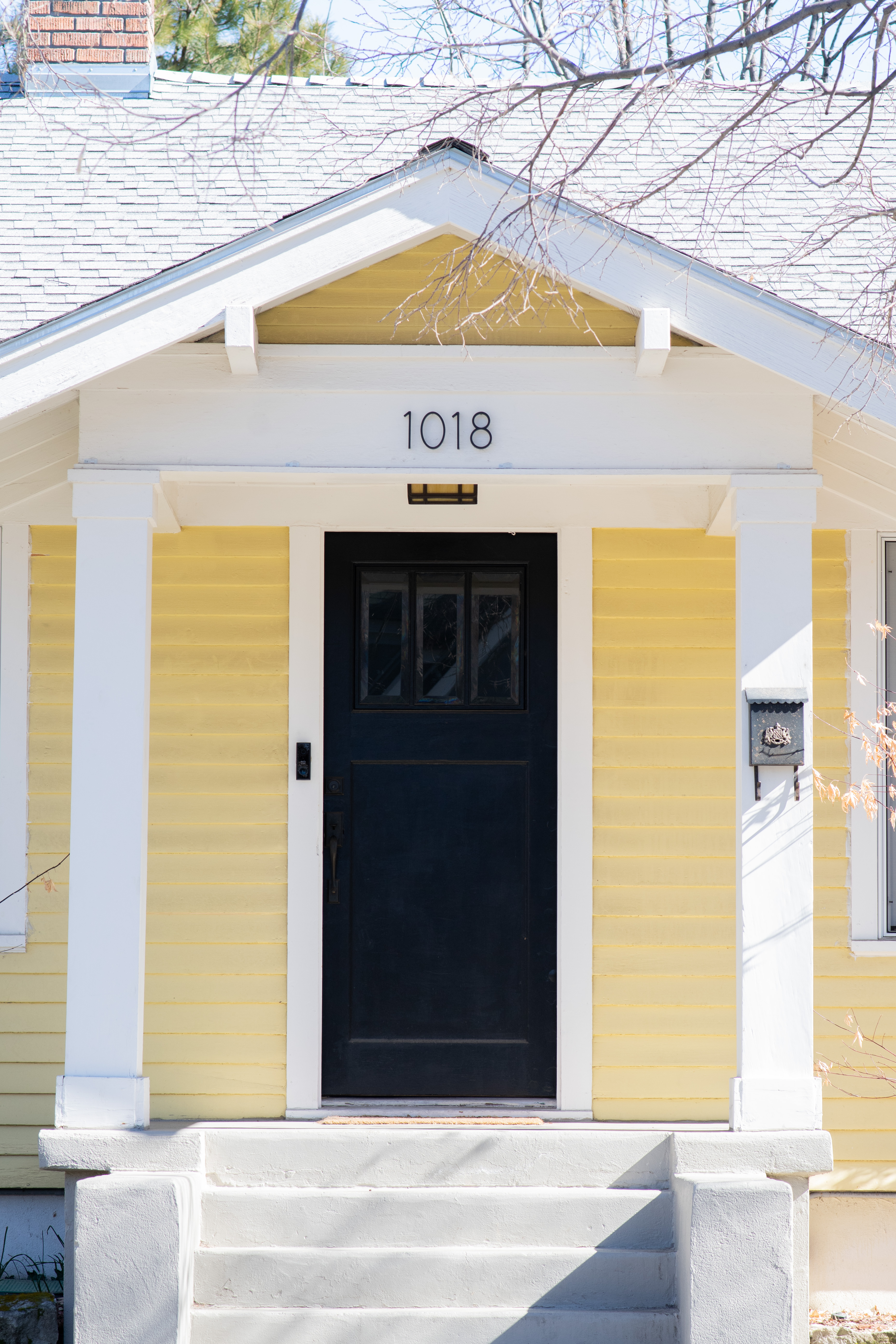 A black door on a yellow house