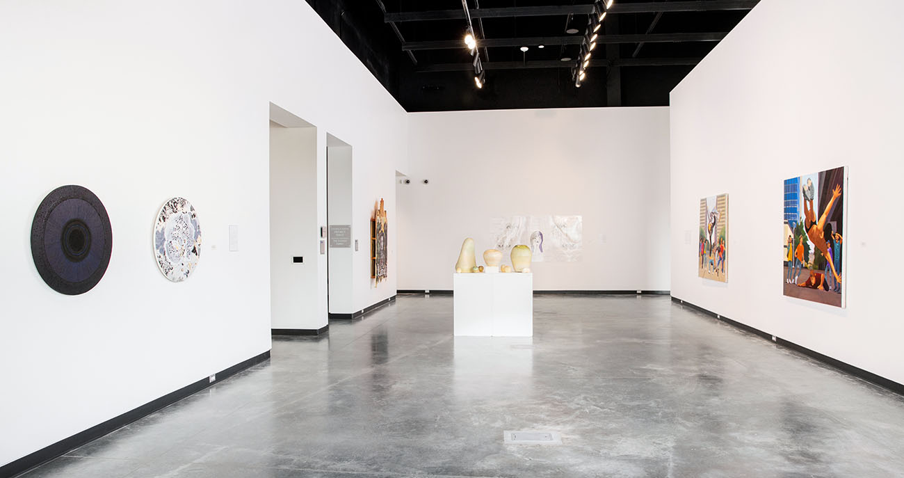 Blue Galleries space with art displayed on walls and pedestals.