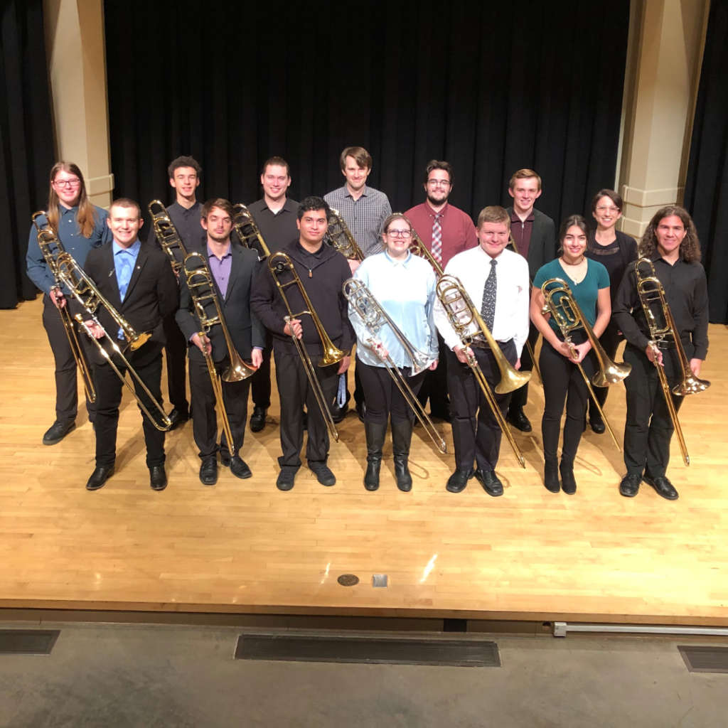 Boise State Trombone Choir standing on the Morrison Center Recital Hall stage and posing with their instruments.