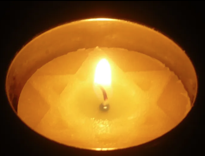 Lit jewish candle on a dark background