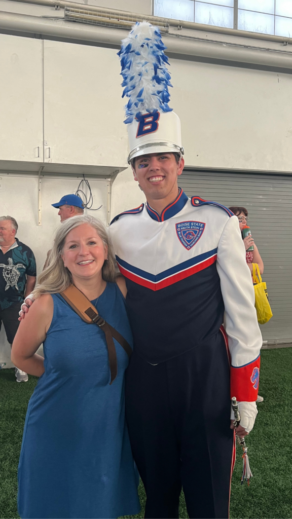 Jacob Scott in marching band uniform, taking picture with parent
