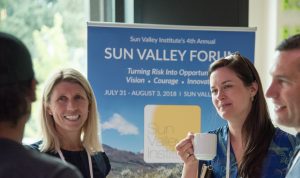 Four people in conversation in front of Sun Valley Institute sign