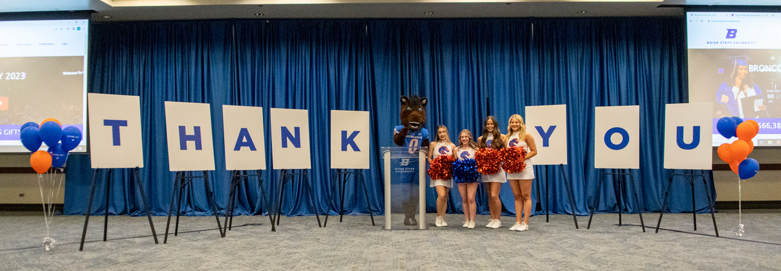 buster and the cheerleaders at Bronco Giving Day with thank you signs