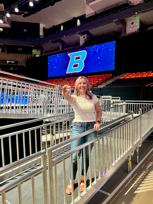 Brigitta Cumiskey holds a BOLD pin while standing on a ramp in the arena