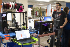 Student working on a 3D printer in the CID space.