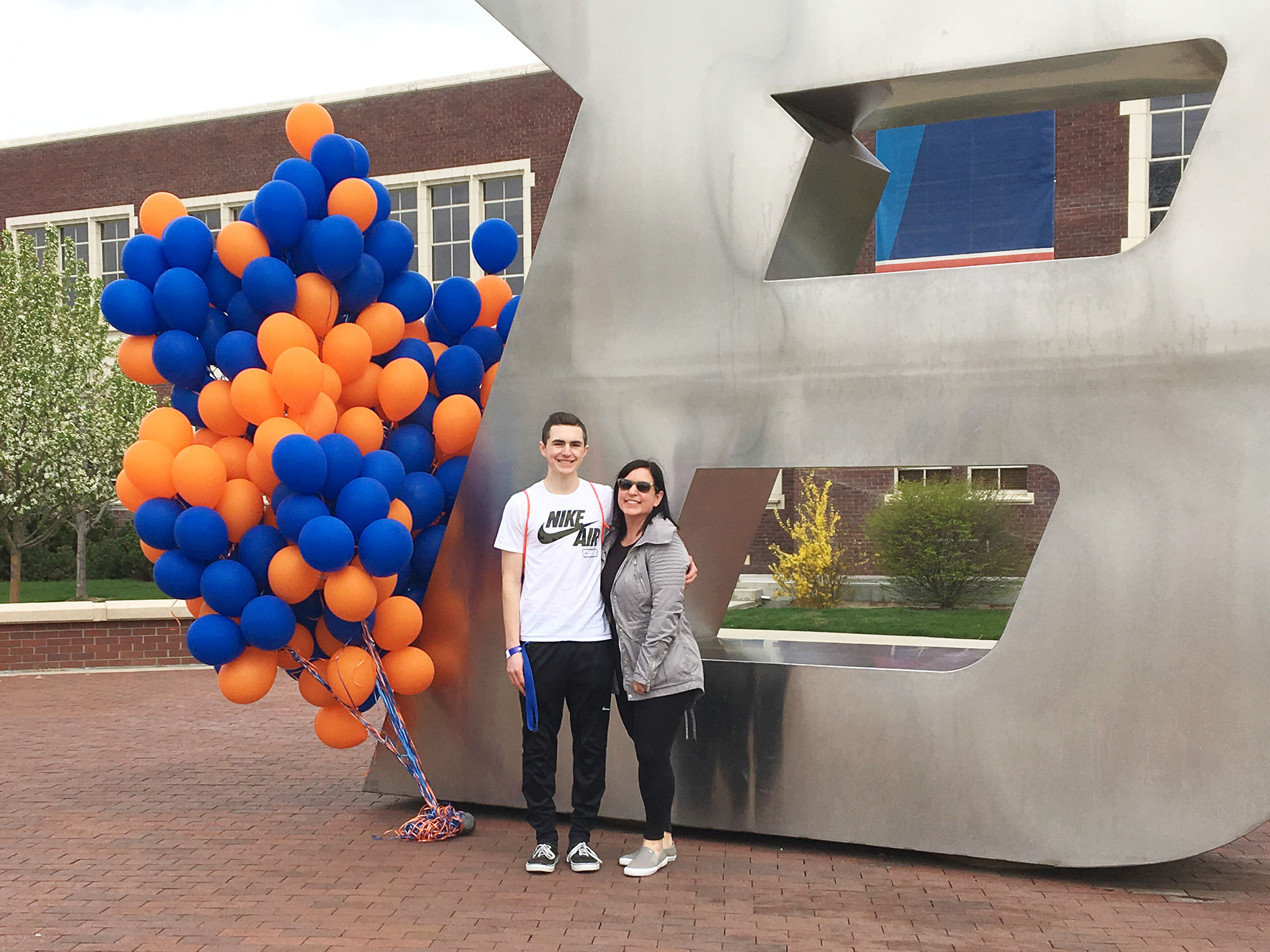 Jodi McCrosky poses in front of the Boise State B with her son.