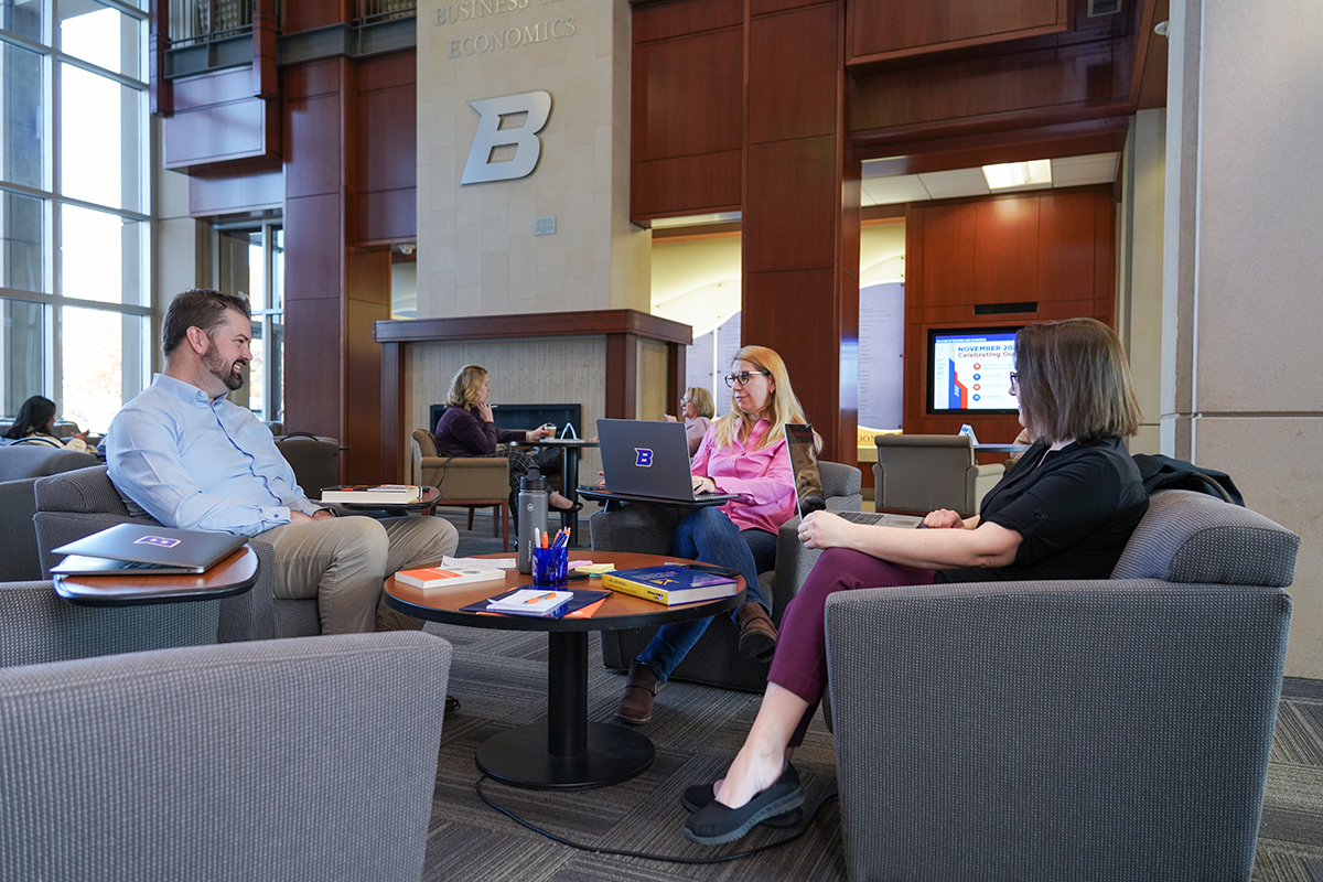 Three Boise State MBA students discuss their courses in the Boise State University College of Business and Economics building.