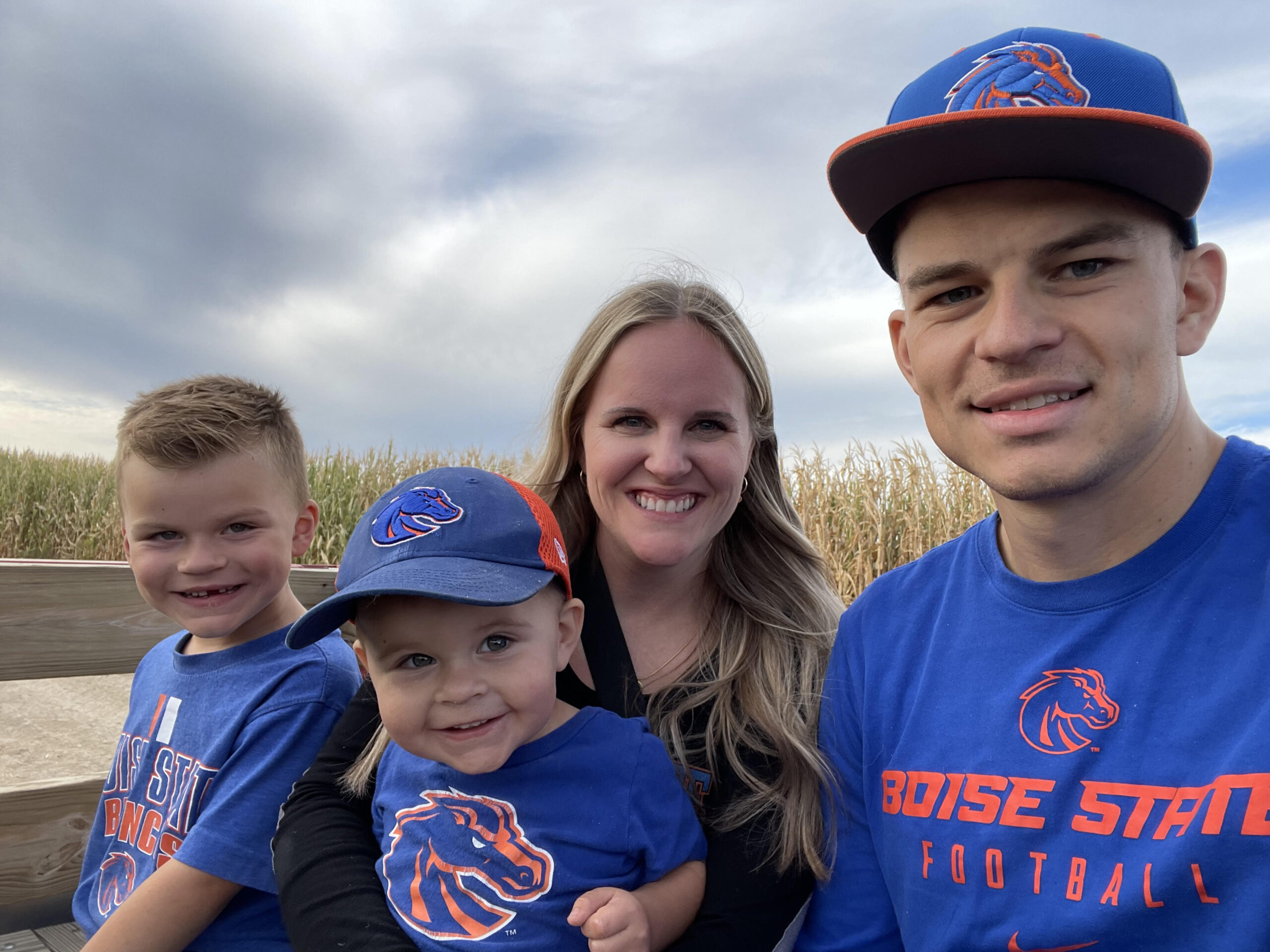 Preston Schow with his wife and two young children in Boise State gear.