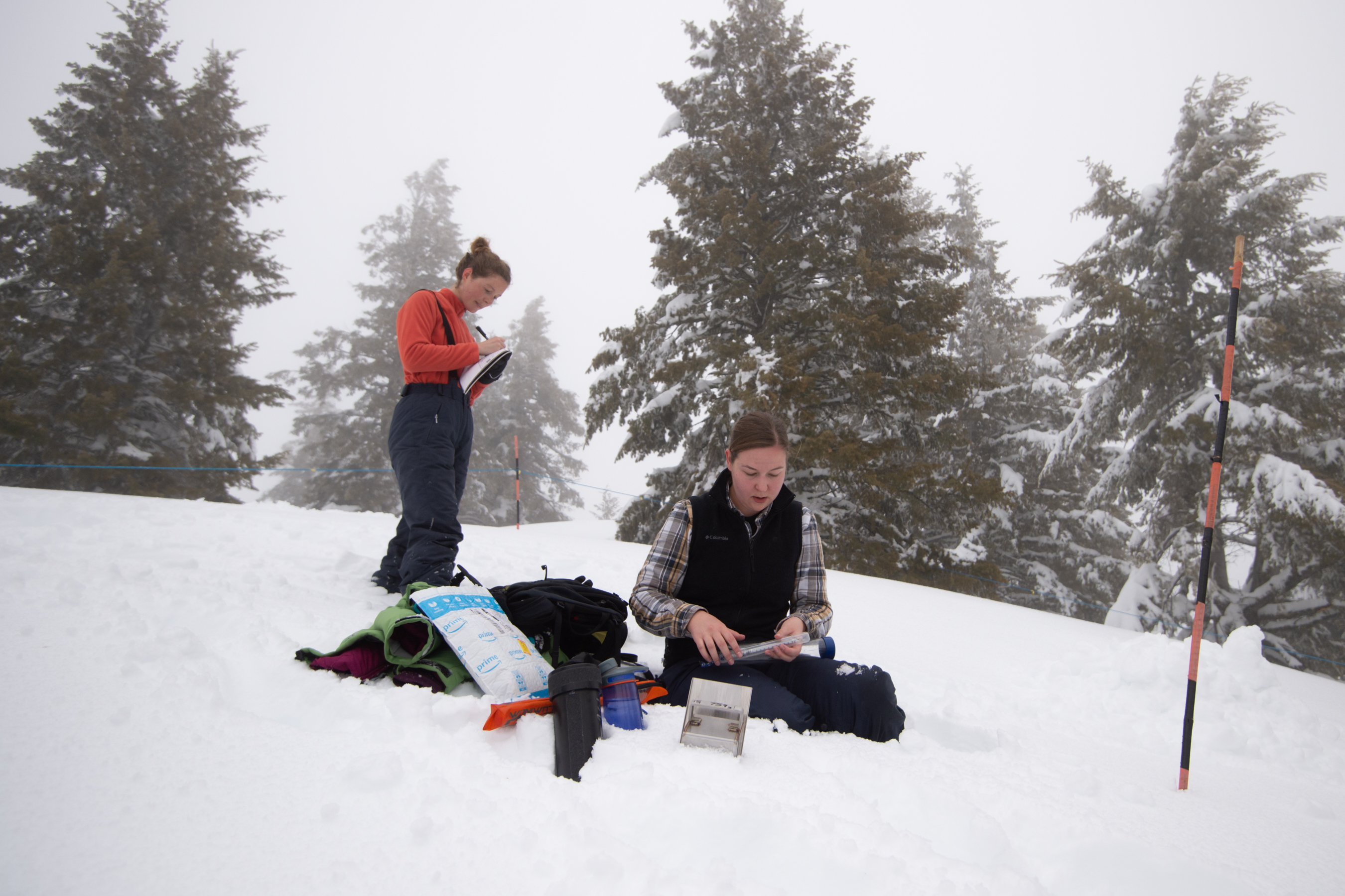 Boise State grad students Isis Brangers and Allison Vincent take snowpack measurements at a test site at Bogus Basin as part of the NASA SnowEx program, photo Patrick Sweeney