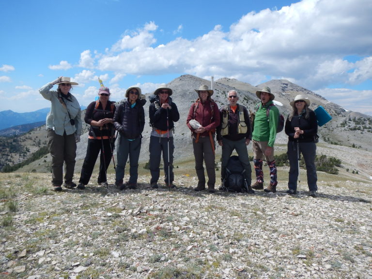 Team of scientists posed on a mountain summit (photo by Beth Corbin)