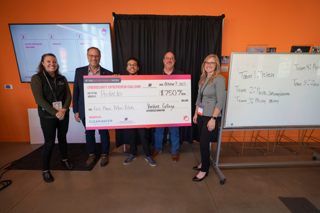 Youssef standing with Judges with his prize check award