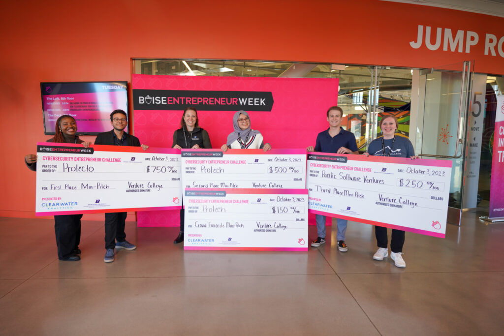 Cybersecurity Entrepreneur Challenge 2023 Winners with Checks in front of Boise Entrepreneur Week Banner