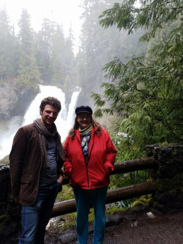 Two people enjoying a waterfall.