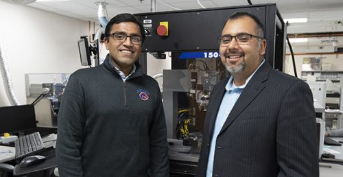 Two men smile in a lab