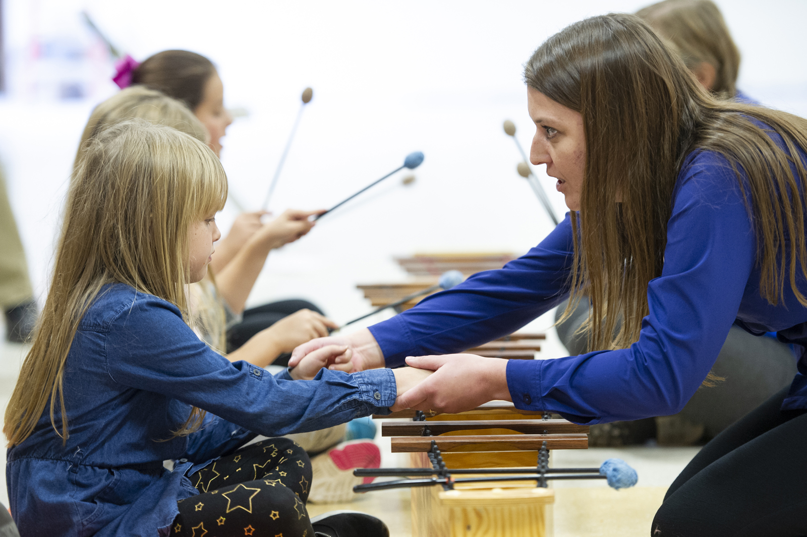 Amy Wickstrom teaching children to play the xylophone