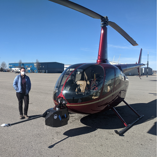 Karina standing with the helicopter with the Lidar sensor mounted to the front at Silverhawk Aviation before take off. Photo Credit: Josh Enterkine