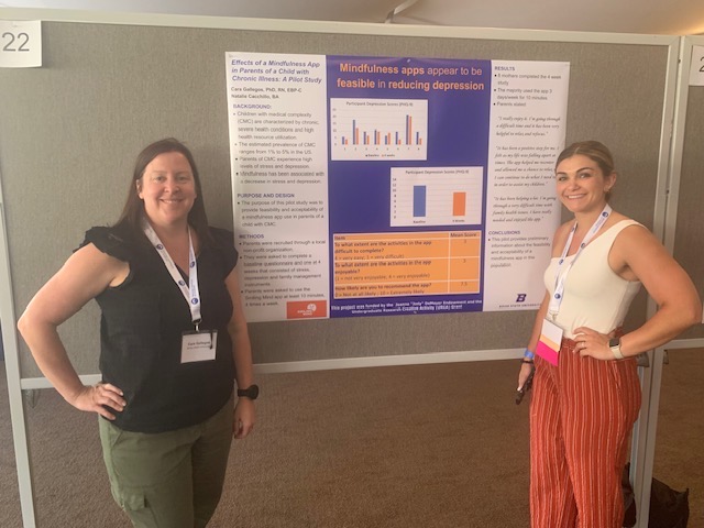 Dr. Cara Gallegos and Natalie Cacchillo stand with their poster presentation.