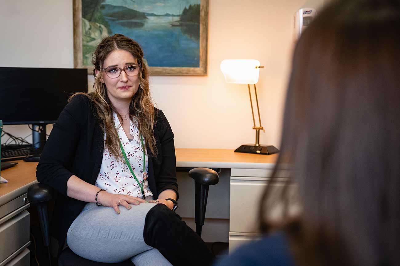 Master of Social Work alumni Amy Rigenhagen listens to a patient's struggles with addiction