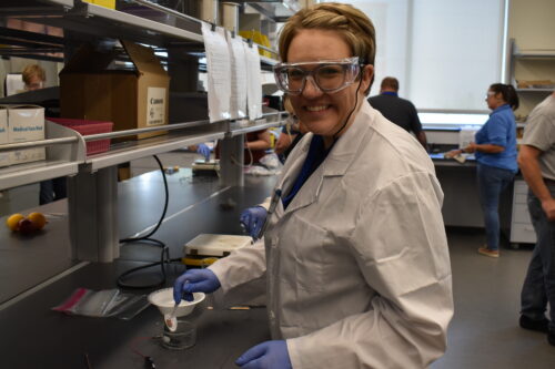 An Idaho teacher poses for a quick photo while conducting an experiment during the ASM Camp.