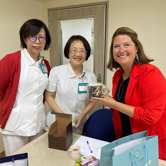 Walters smiles with two Taiwanese nurses and holds a gift.