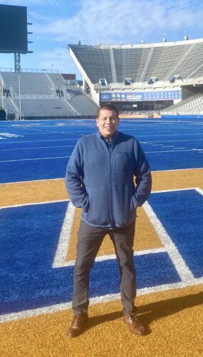 A person poses on Boise State football field 