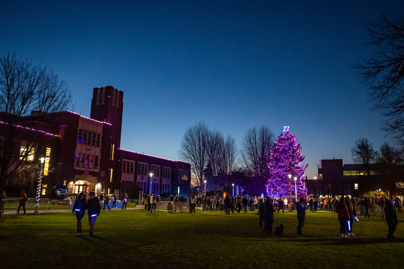 Boise State Quad with an illuminated holiday tree and persons gathered