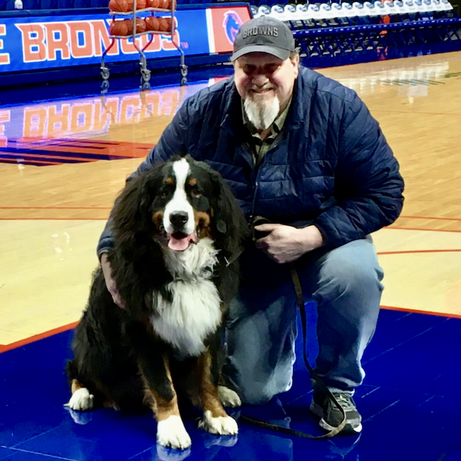 Steve Marlatt and his dog, Earl, pose on the basketball court of ExtraMile Arena.