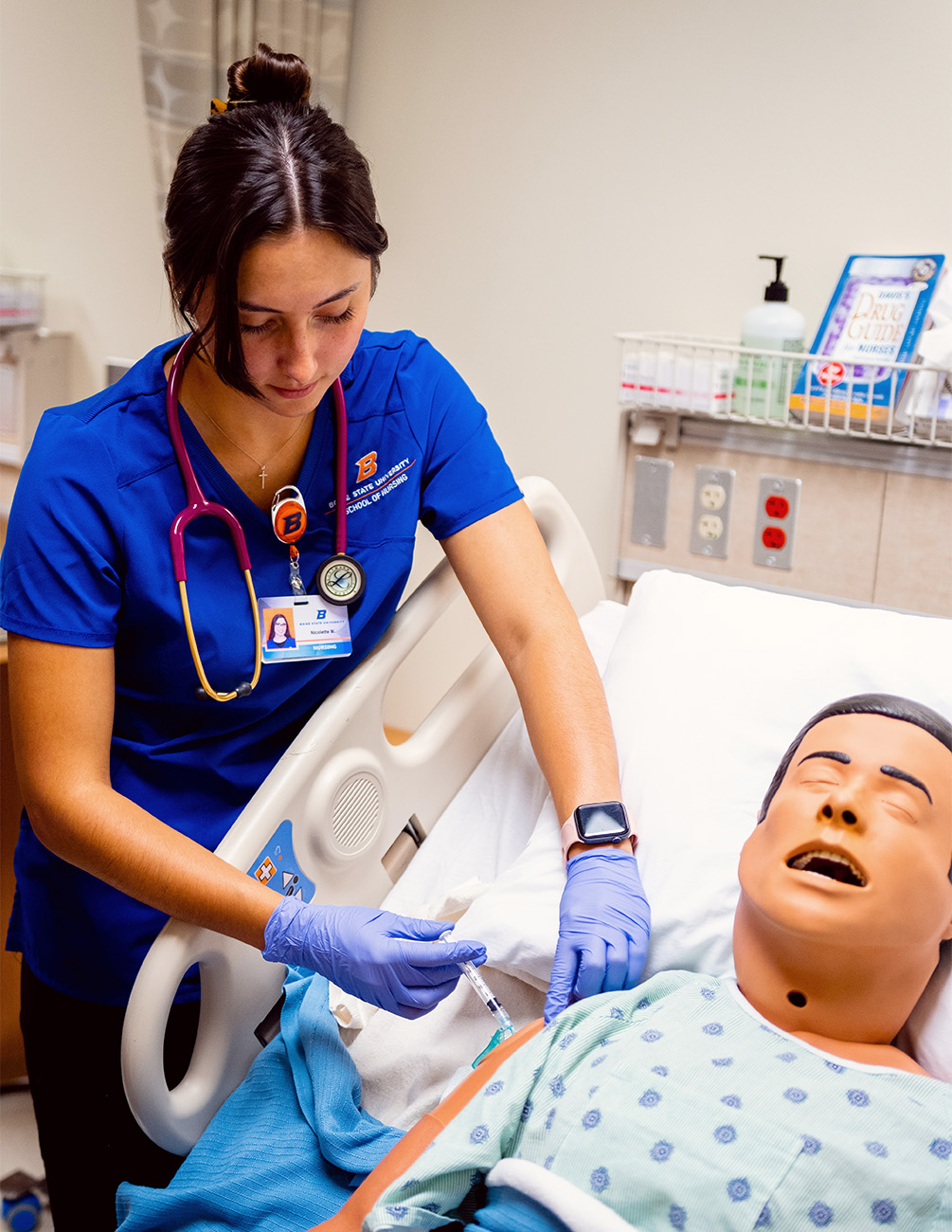 A nursing student gives a manikin an injection in the College of Health Sciences Simulation Center.