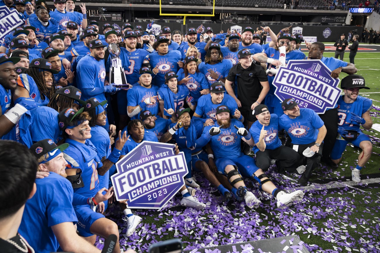 Boise State football team posing with Mountain West Championship trophy