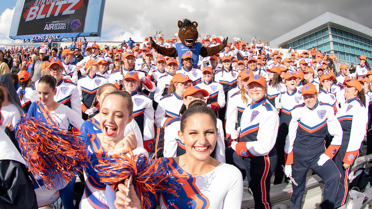 Buster Bronco in the stands with the blue thunder marching band