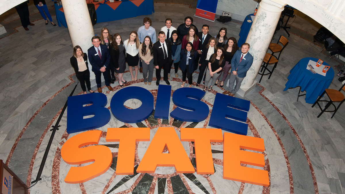 ASBSU standing in the capital rotunda with large in blue and orange spelling out Boise State