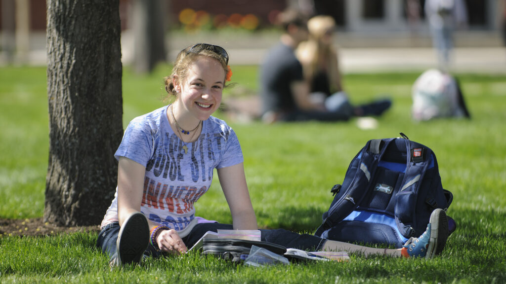 Student studying outside on campus in the spring