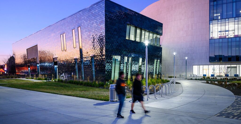 Students walking by the Center for the Visual Arts at sunset.