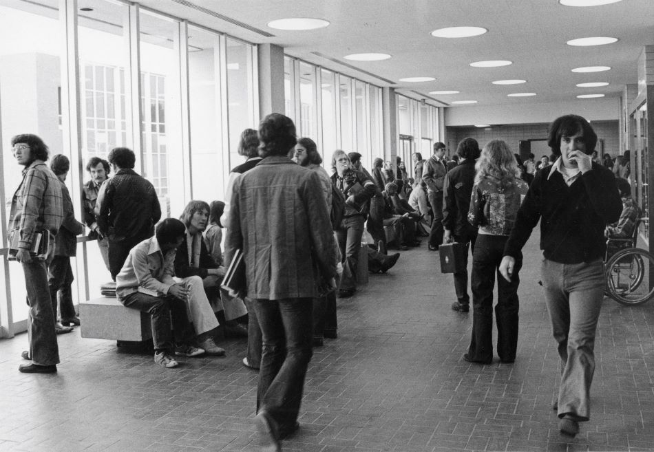 The lobby of the old Business Building (now Riverfront Hall) full of students, March 1975 (source).