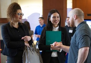 students at a career fair talking to an employer