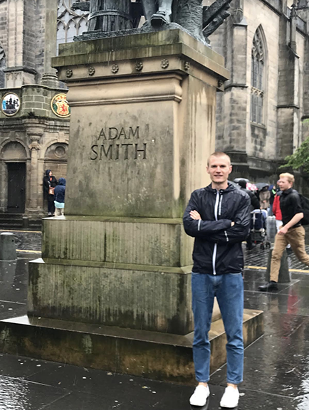 George Feton standing by statue of Adam Smith