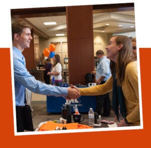 student shaking hands with a recruiter 