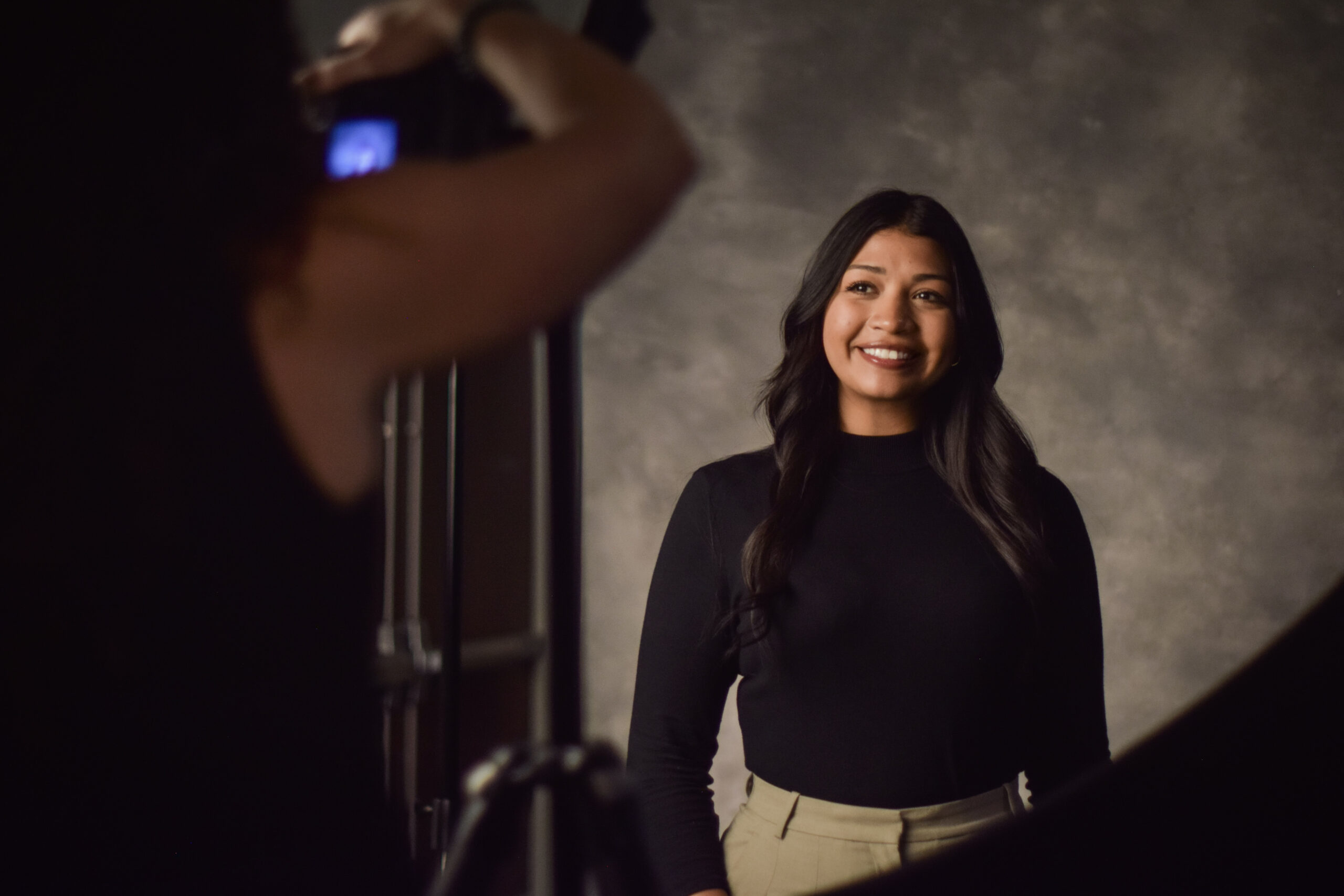 Student smiling at a camera while having a professional headshot taken