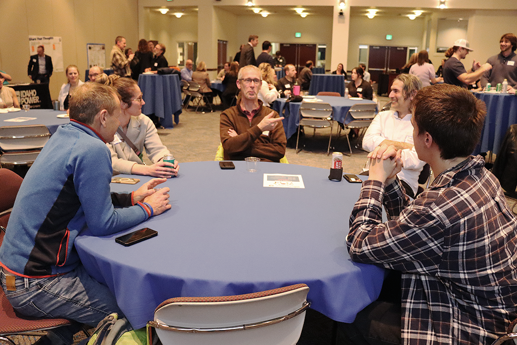 Photo of people chatting at a table at HCRI's networking event on February 1, 2024.